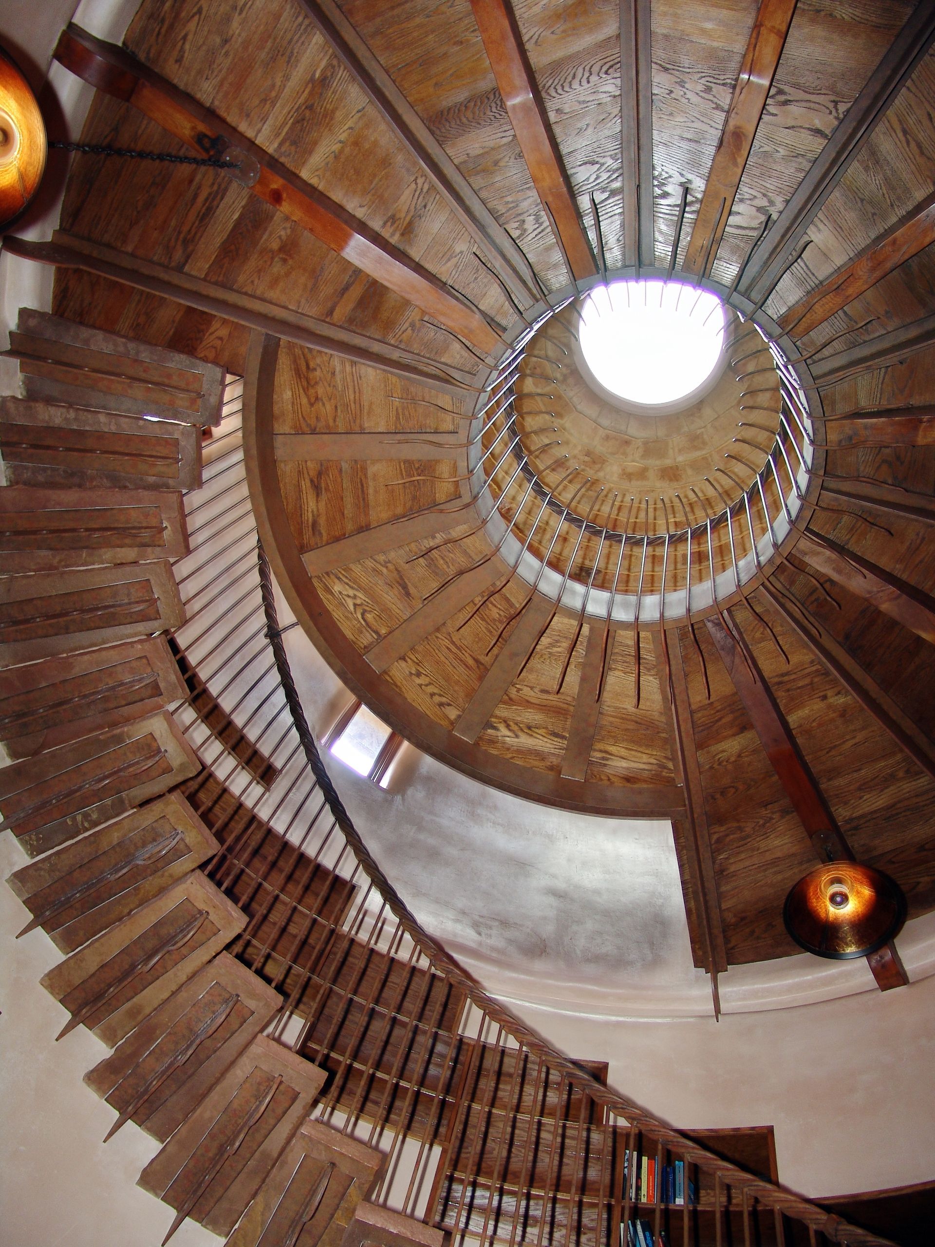 Looking up at a spiral staircase with a light at the top