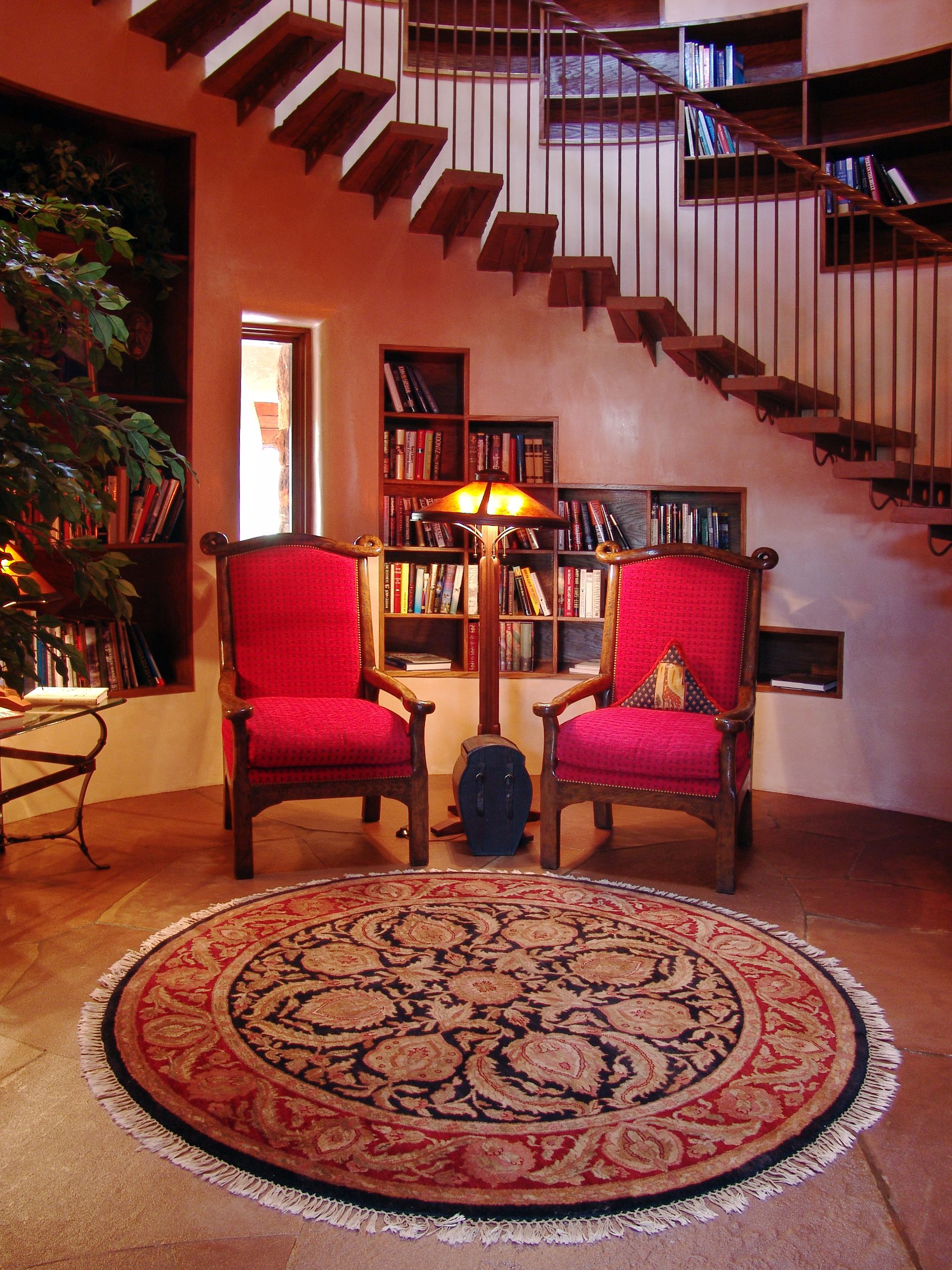 A living room with two red chairs and a round rug