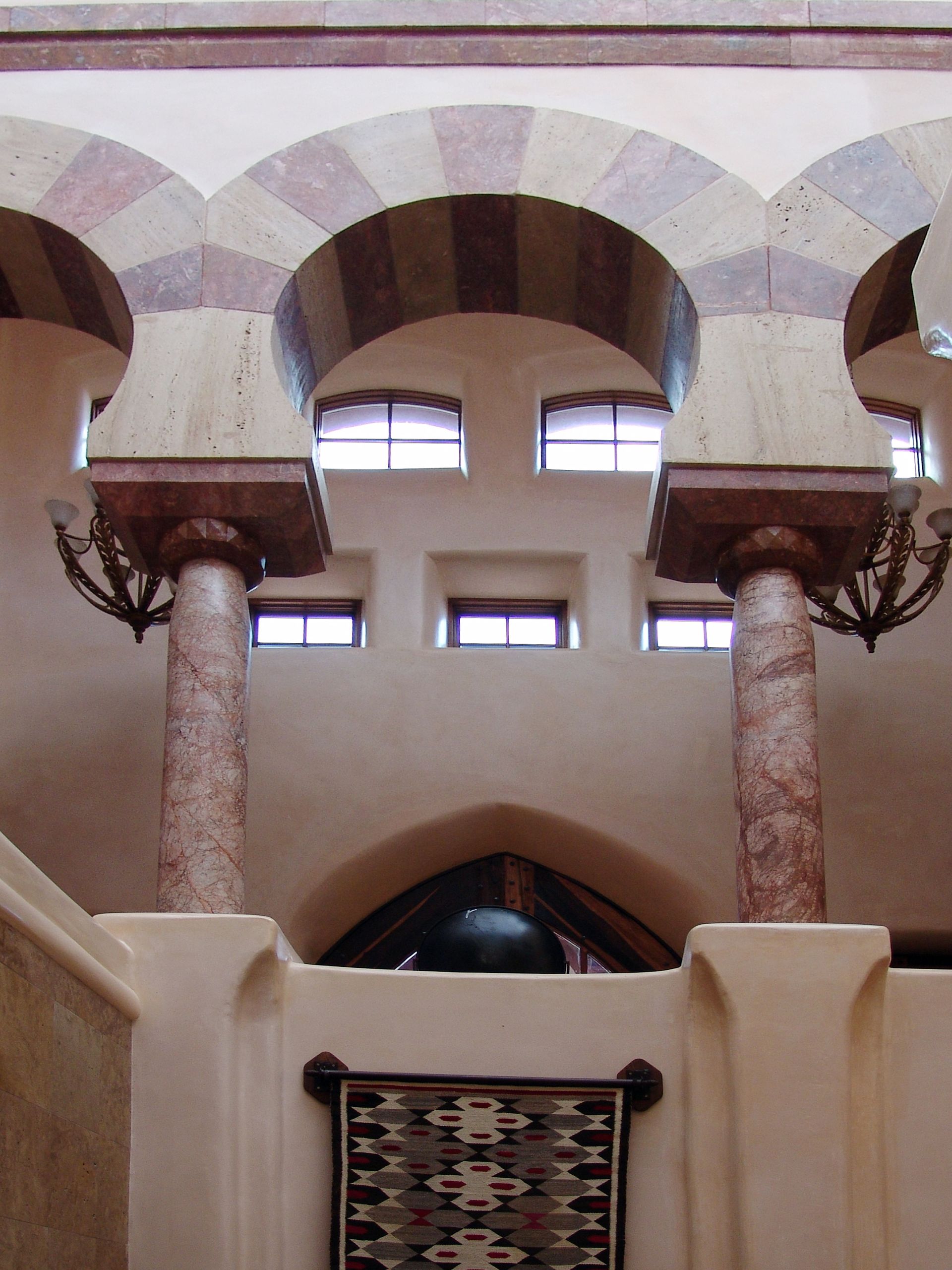 A building with arches and columns and a rug on the wall
