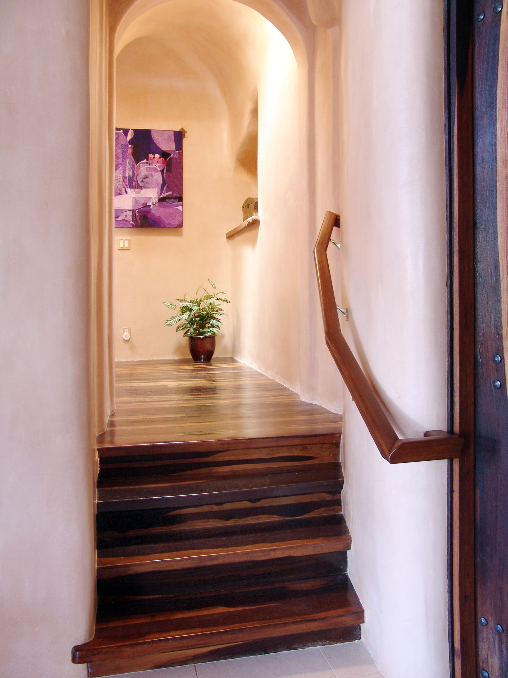 A wooden staircase leading up to a painting on the wall