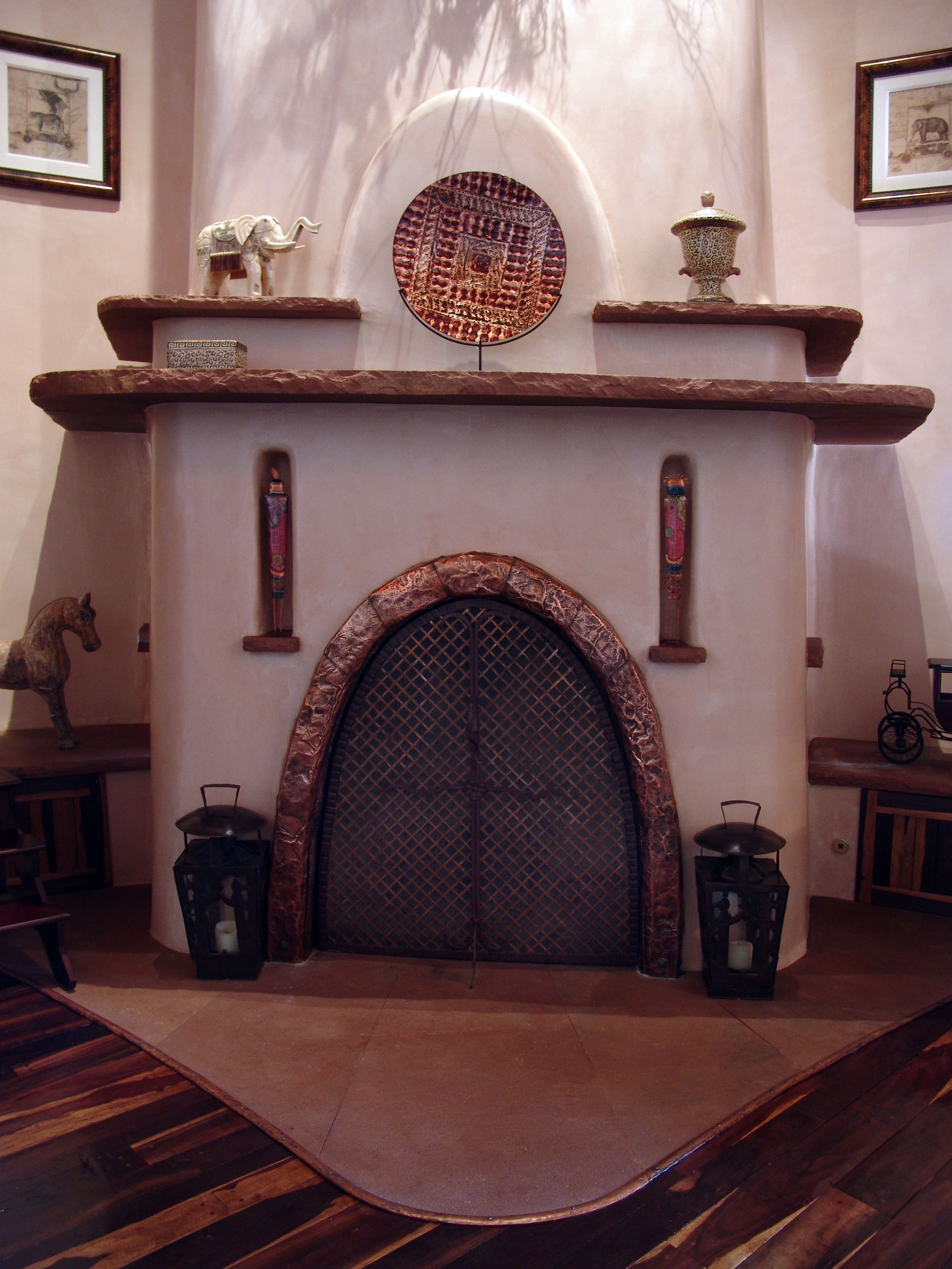 A fireplace with two lanterns in front of it