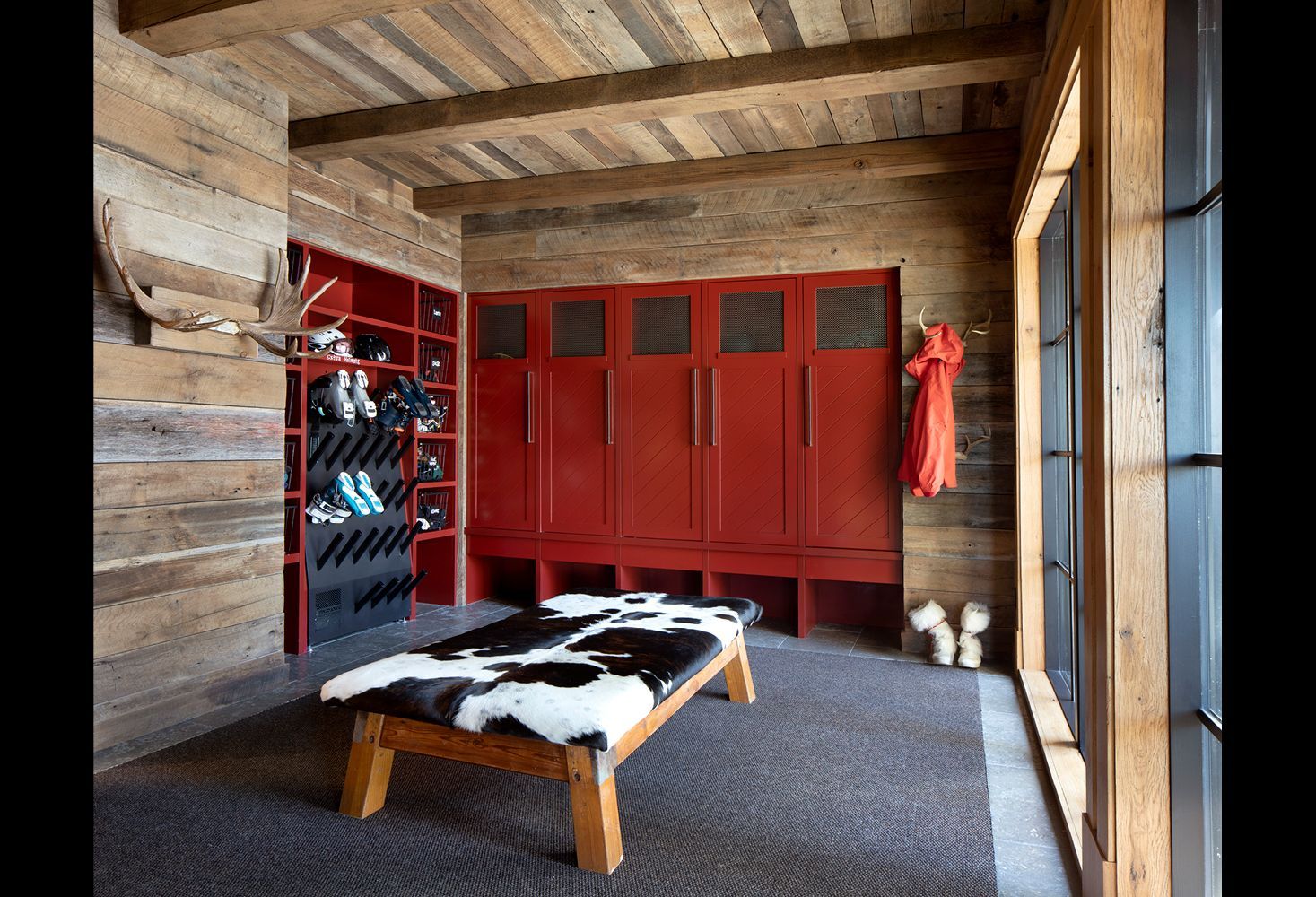 A room with red cabinets and a bench in it