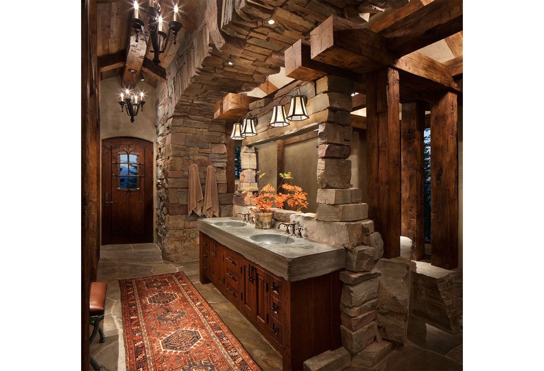 A bathroom with two sinks , a rug and a chandelier.