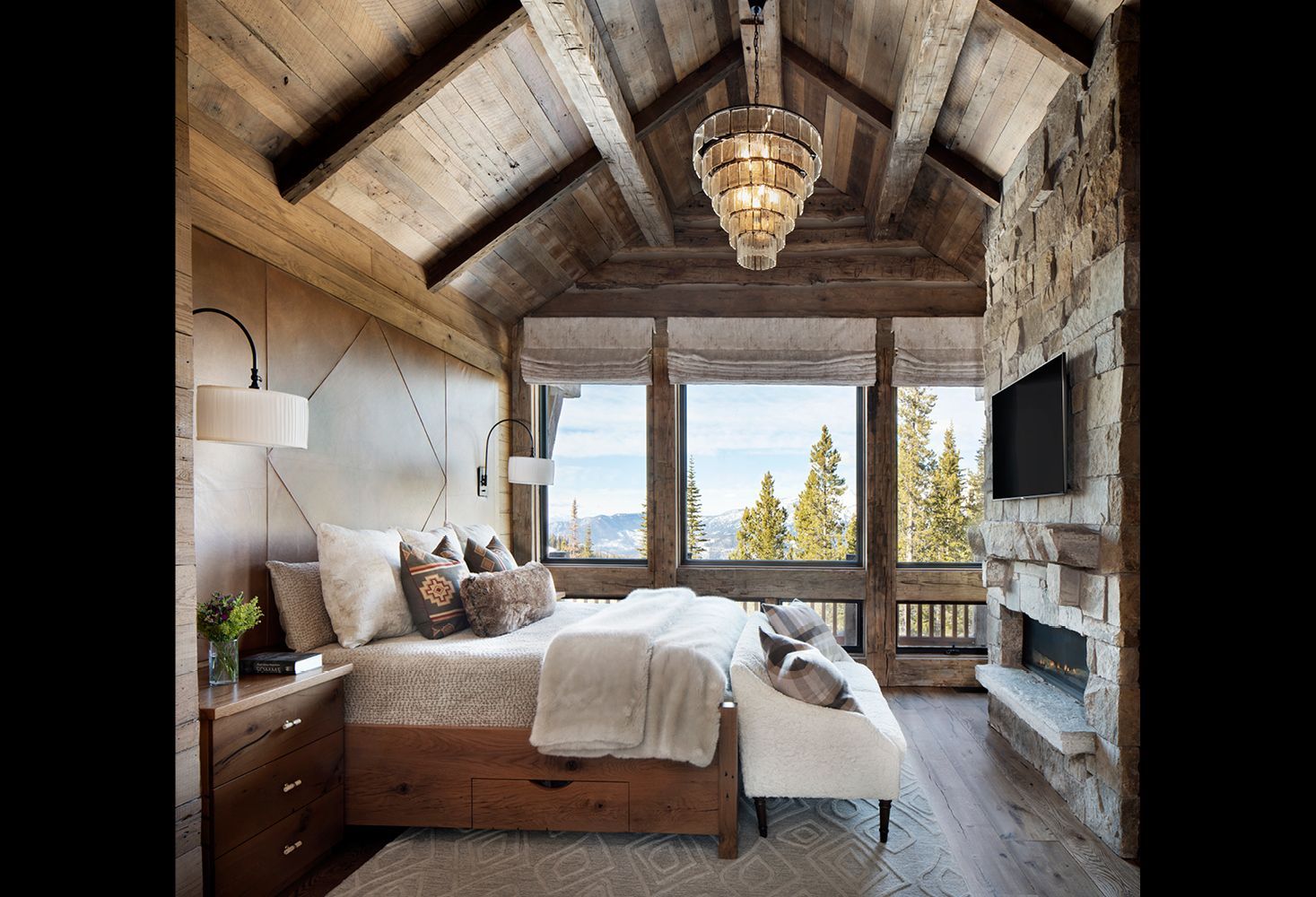 A bedroom with a king size bed and a fireplace.
