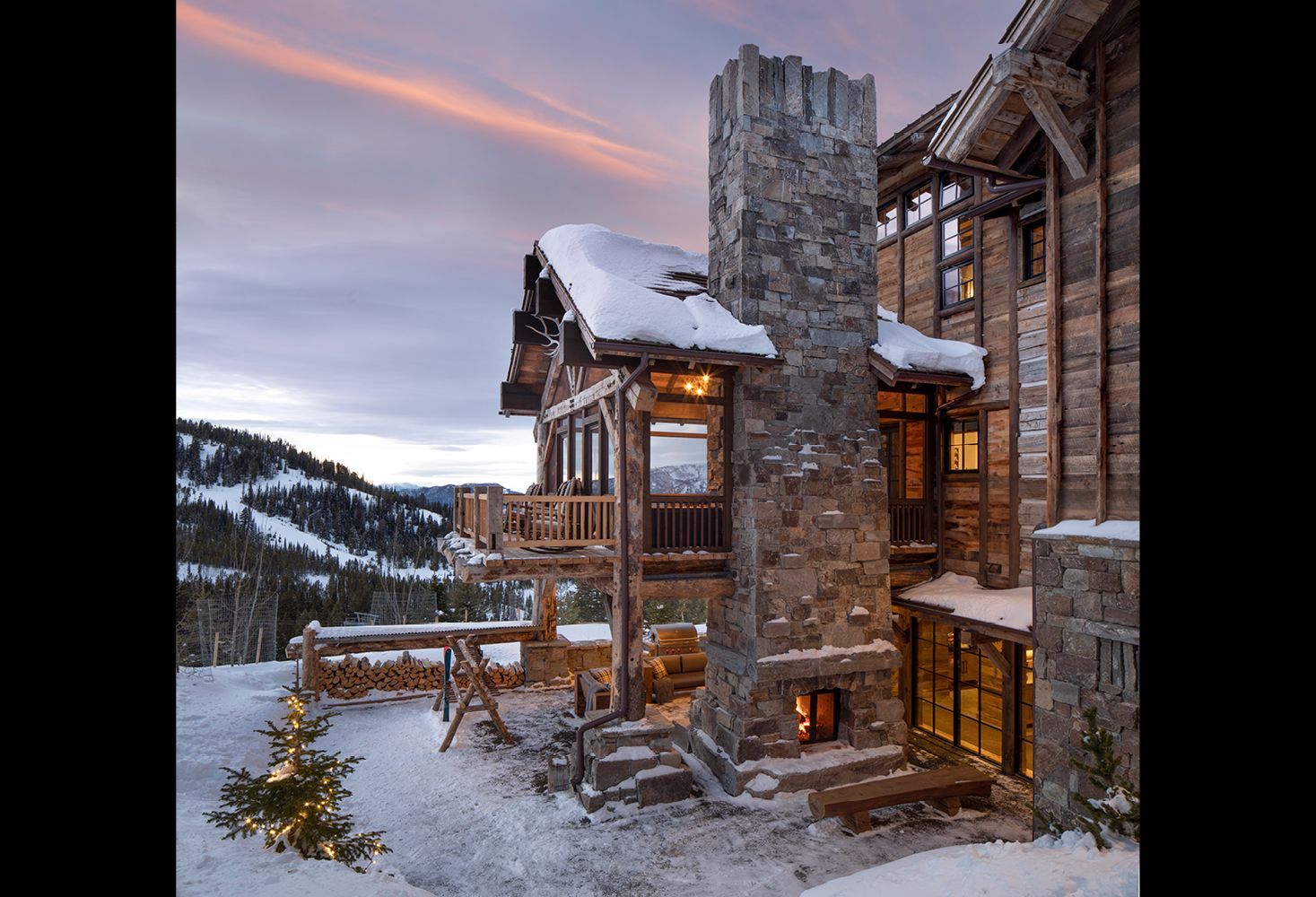 A large stone house with a fireplace in the snow