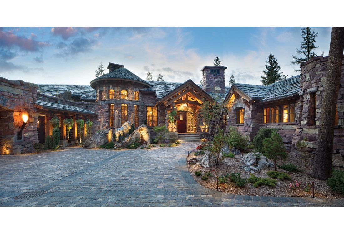 A large stone house with a driveway leading to it.