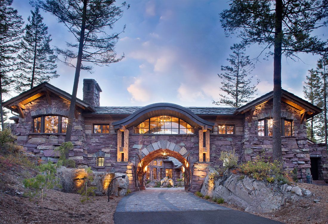 A large stone house with a driveway leading to it