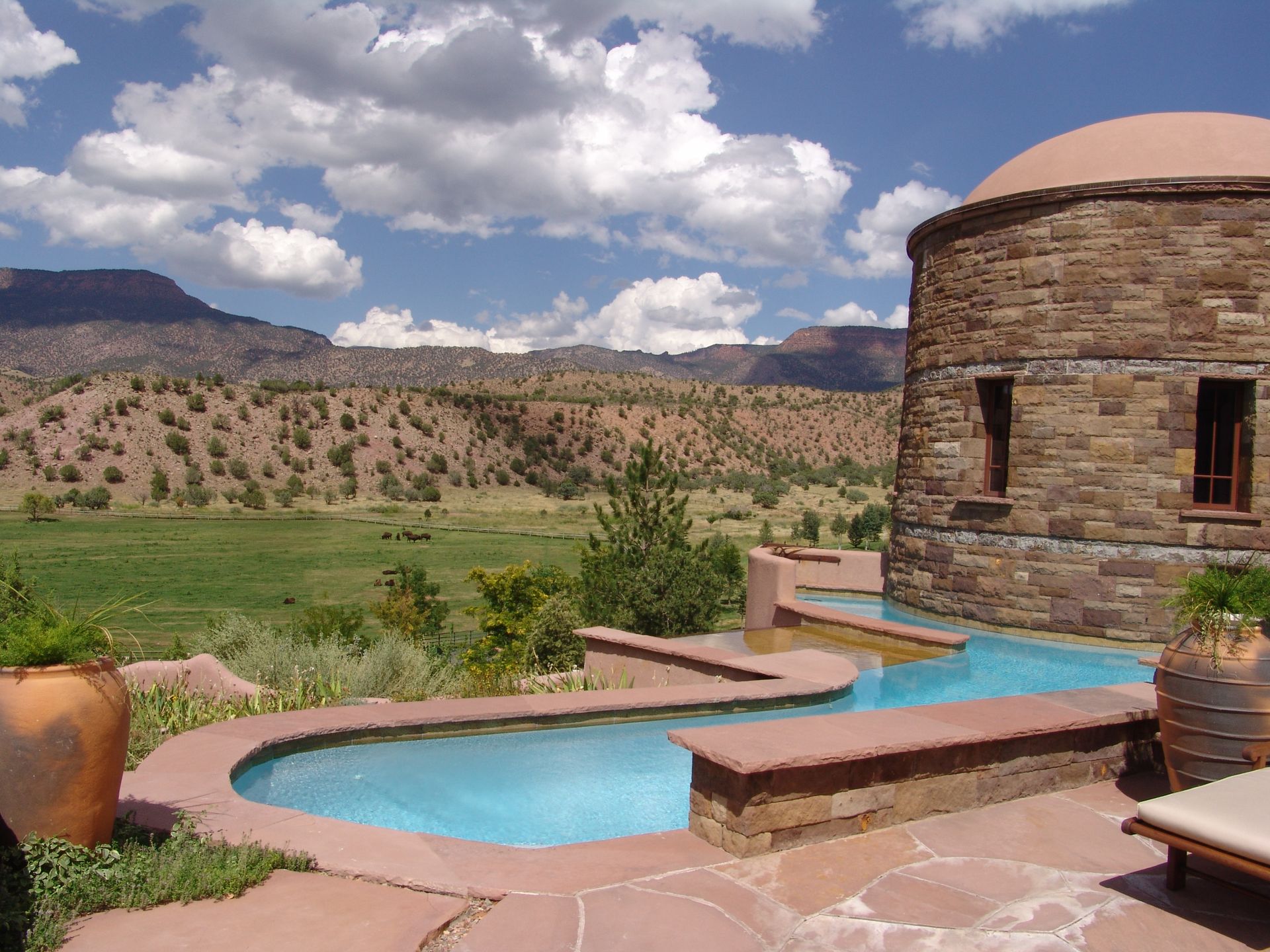 A large stone building with a swimming pool in front of it
