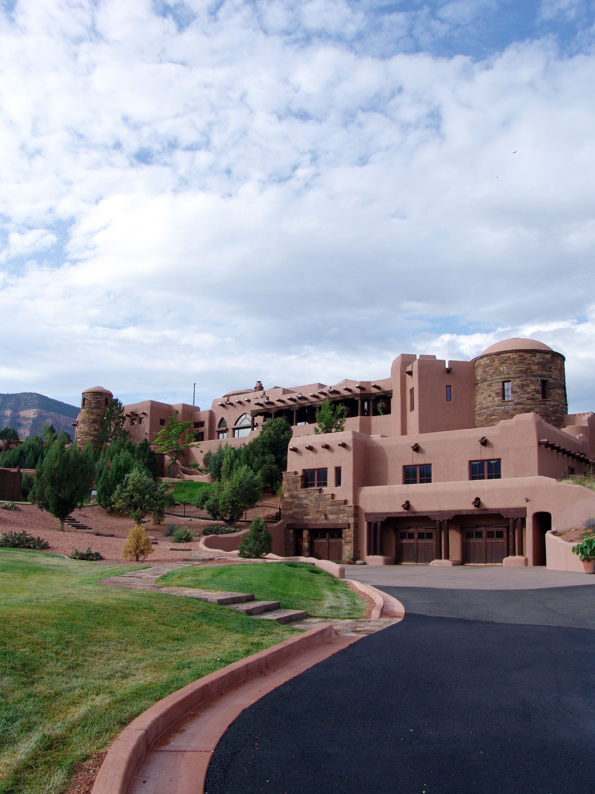 A large building with a lot of windows is surrounded by grass and trees