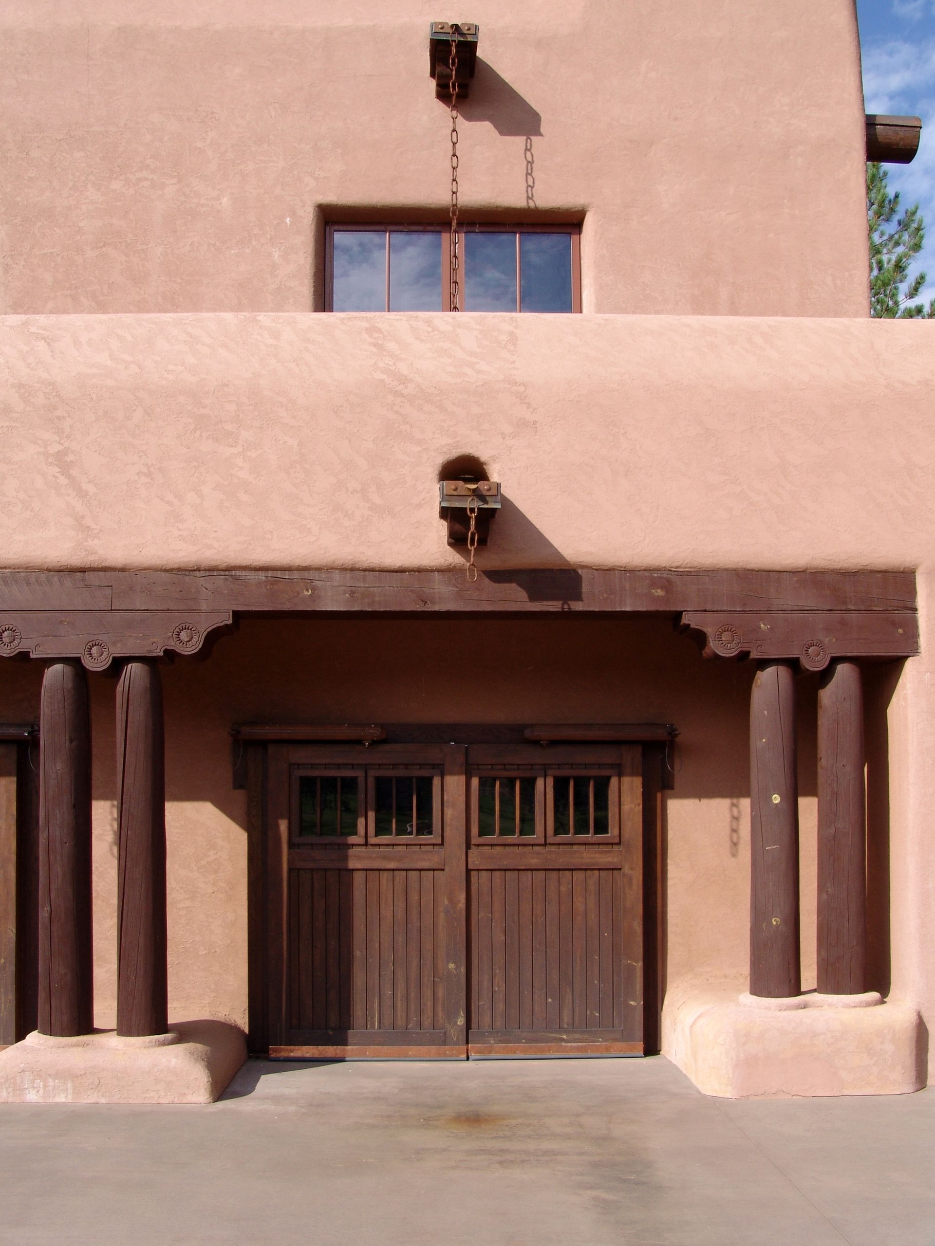 A building with a wooden garage door and columns