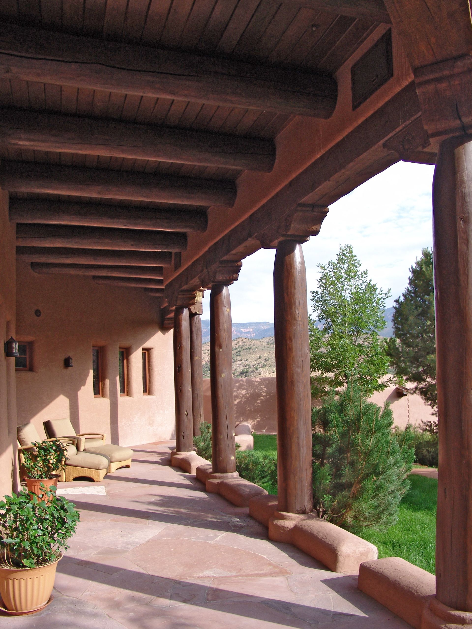 A wooden porch with a few potted plants on it
