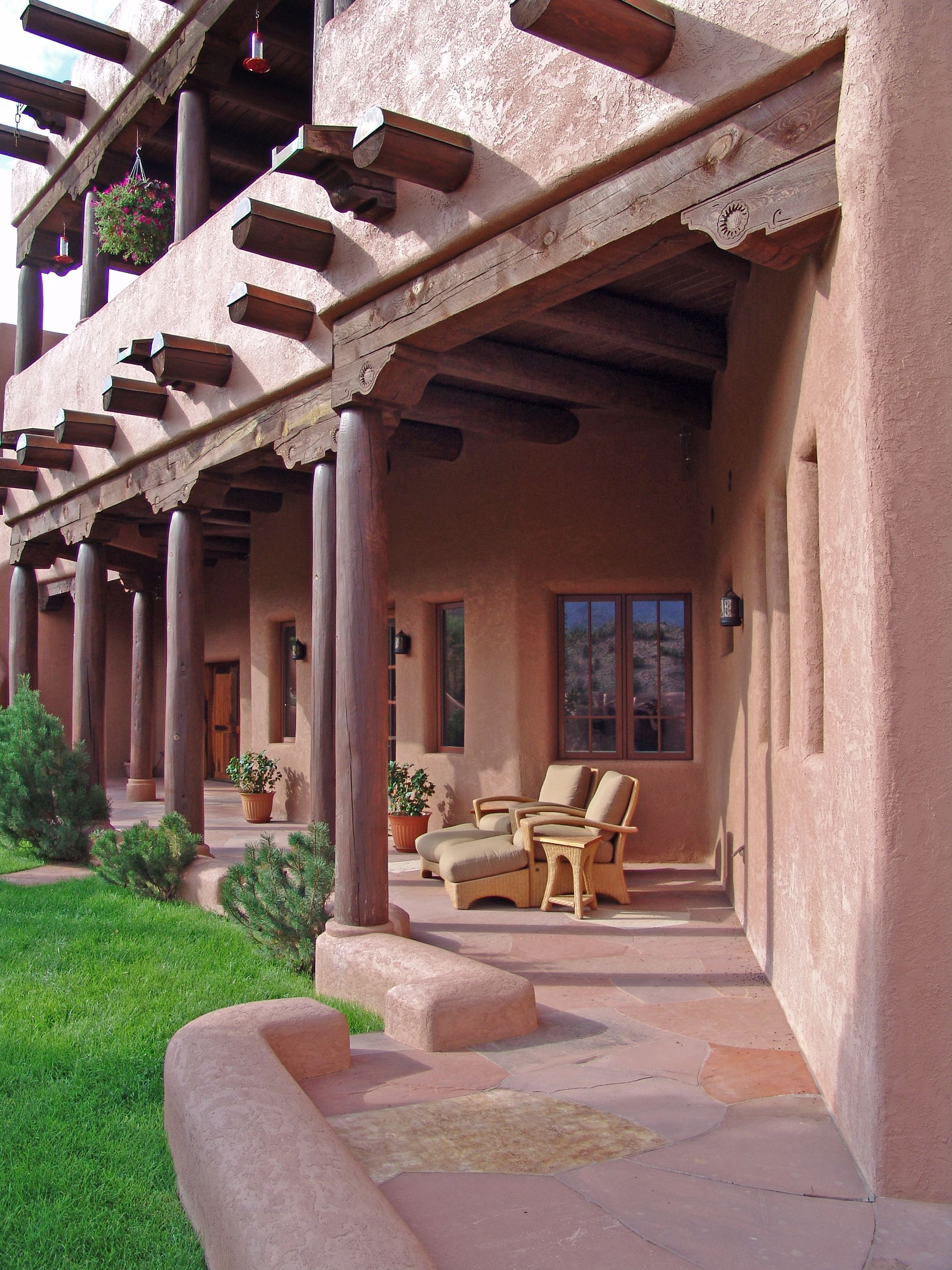 A large building with a porch and chairs on it
