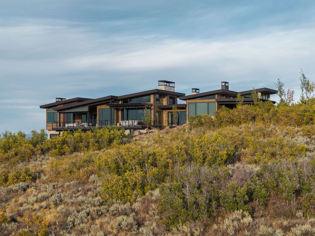 A large house is sitting on top of a hill in the middle of a field.