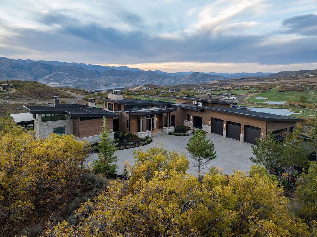 A large house is sitting on top of a hill surrounded by trees.