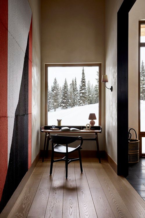 A hallway with a desk and chair in front of a window