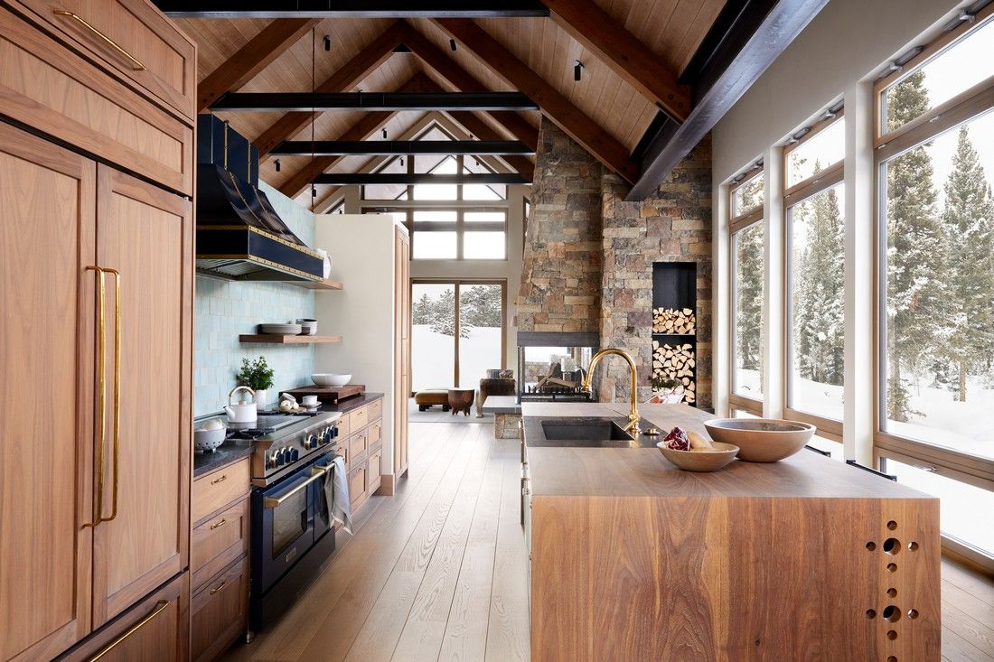 A kitchen with wooden cabinets , a black stove , and a large island.