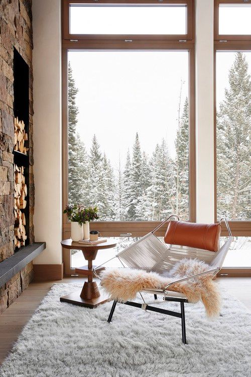 A chair is sitting in front of a large window in a living room.