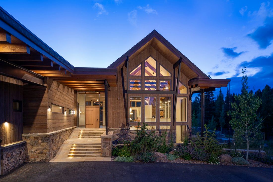 A large house with a lot of windows is lit up at night.