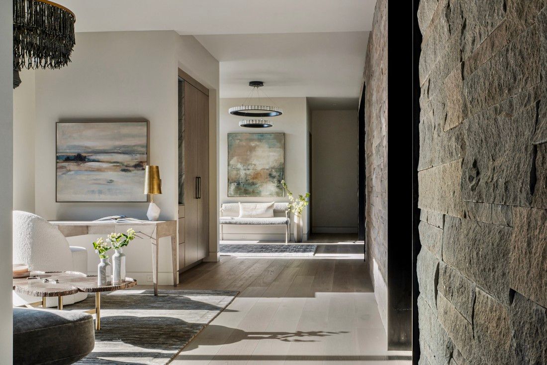 A living room with a chandelier and a painting on the wall.