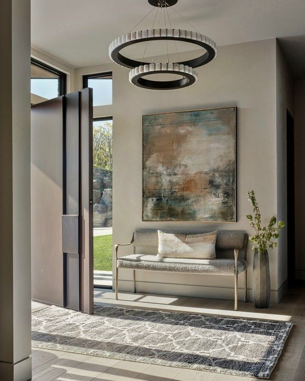 A hallway with a bench and a painting on the wall.