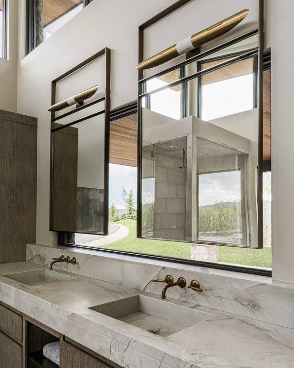 A bathroom with two sinks and two mirrors on the wall.