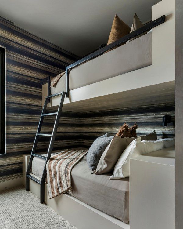 A bedroom with two bunk beds and a ladder