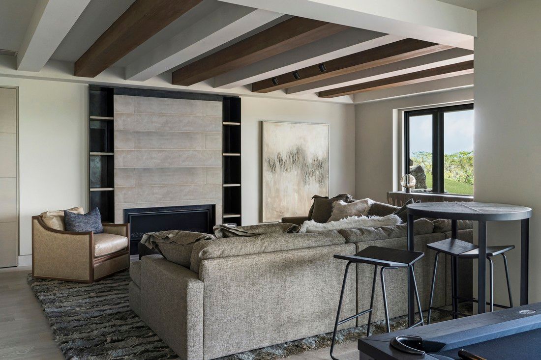 A living room with a couch , fireplace , table and chairs.