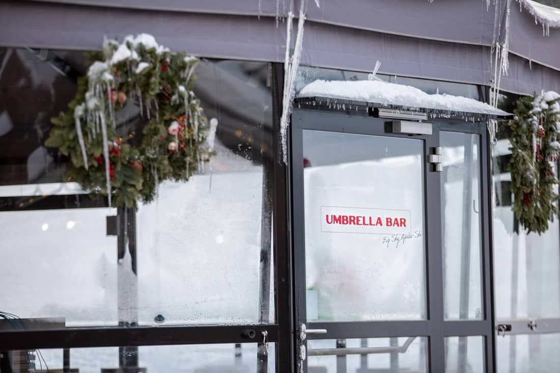 A glass door with a sign that says umbrella & bar on it.