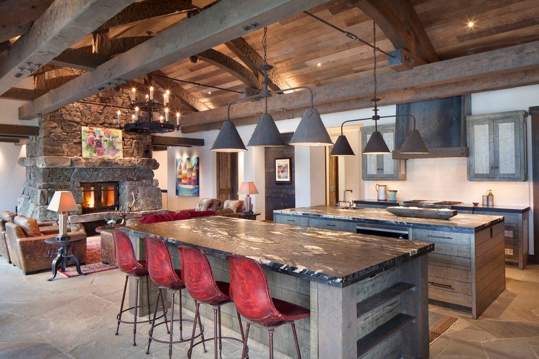 A large kitchen with a large island and red chairs.