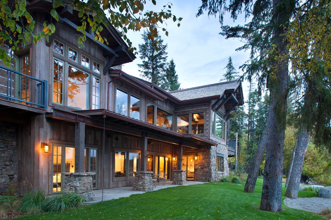 A large house with a lot of windows is surrounded by trees.