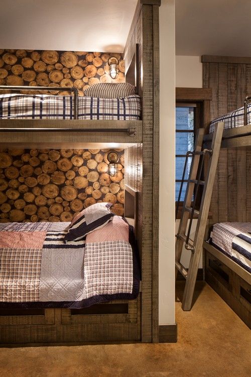 A bunk bed with a ladder in a room with logs on the wall.