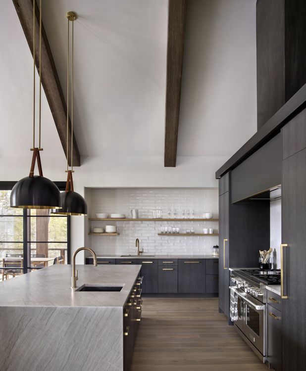 A kitchen with black cabinets and stainless steel appliances