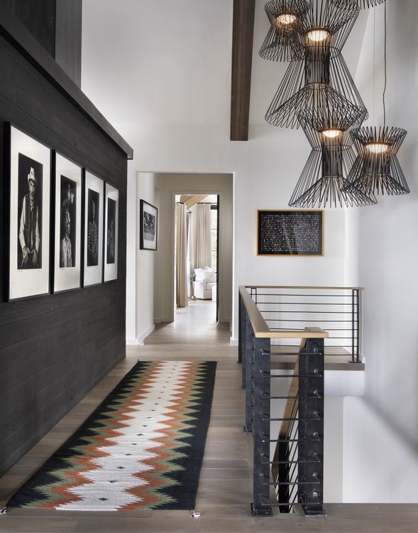A hallway with a rug and pictures on the wall
