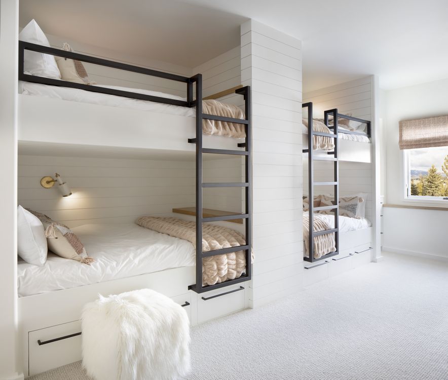 A bedroom with three bunk beds and a window.