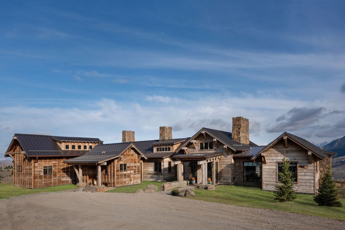 A large wooden house with a lot of windows and chimneys