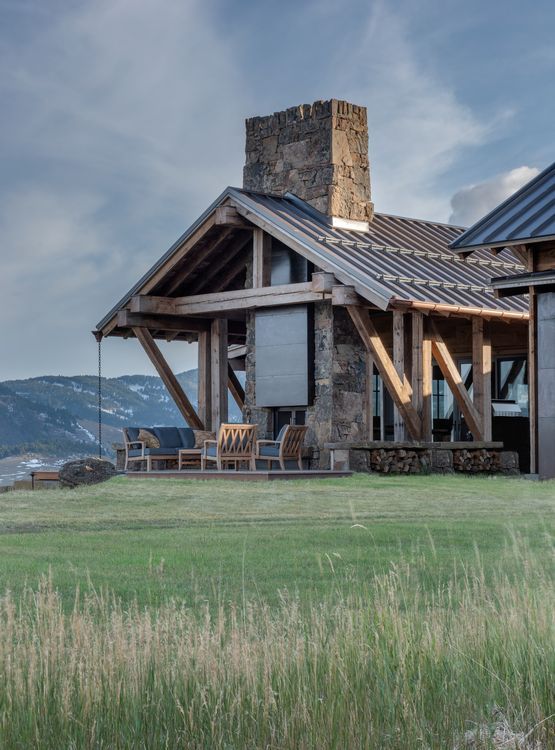 A large house with a large chimney is sitting in the middle of a grassy field.