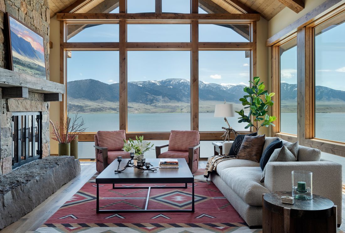 A living room with a view of a lake and mountains