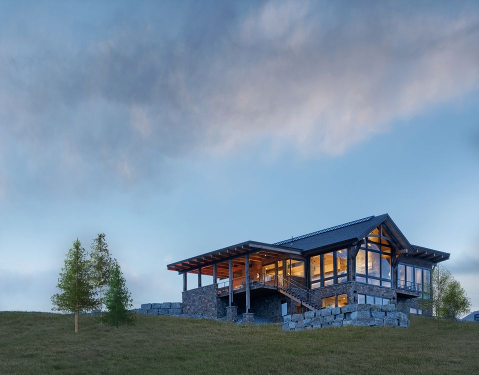 A large house is sitting on top of a grassy hill.