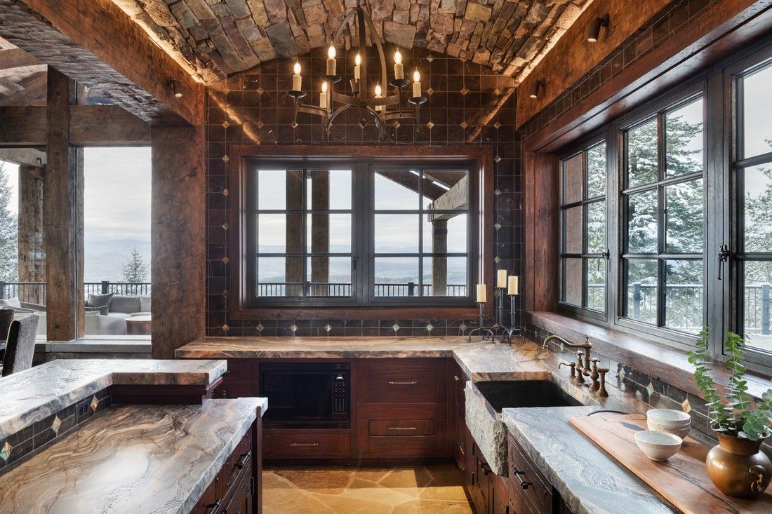 A kitchen with a lot of windows and a chandelier hanging from the ceiling.