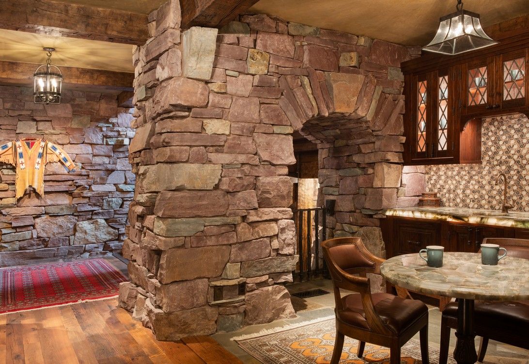 A room with a stone wall and a table and chairs.