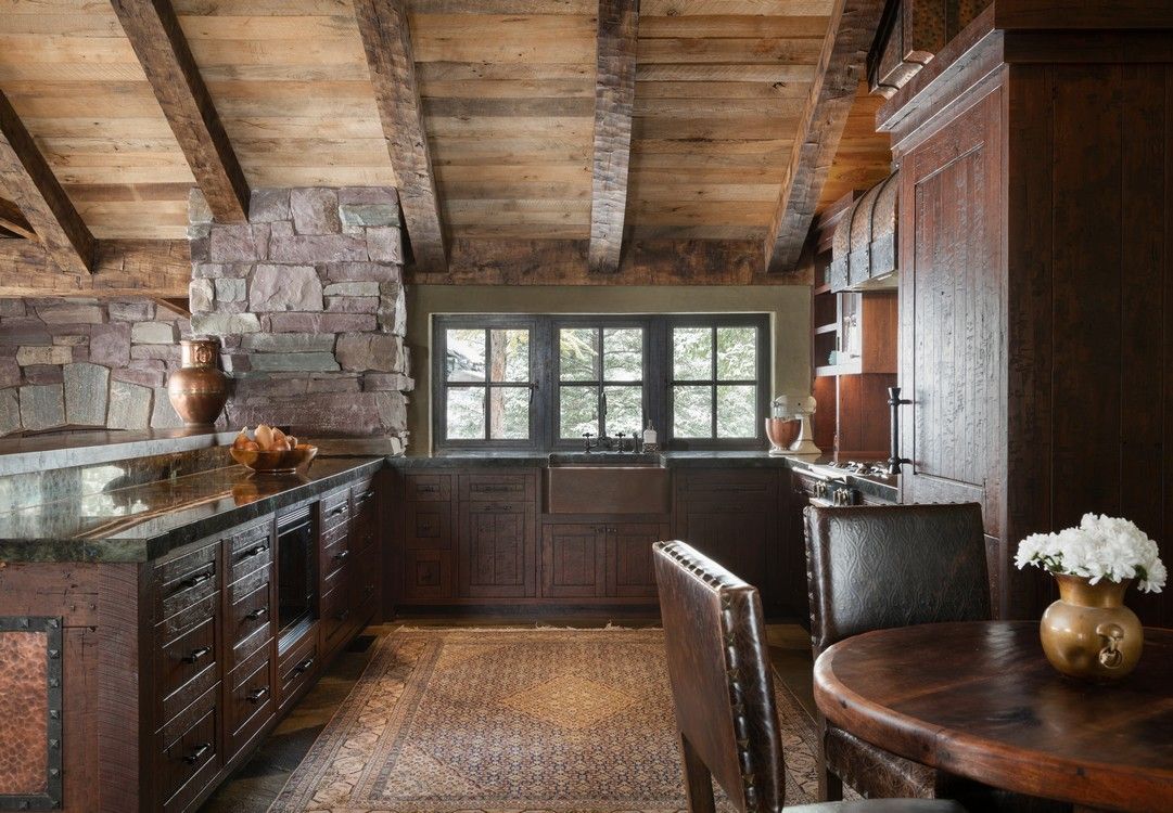 A kitchen with wooden cabinets and a table and chairs