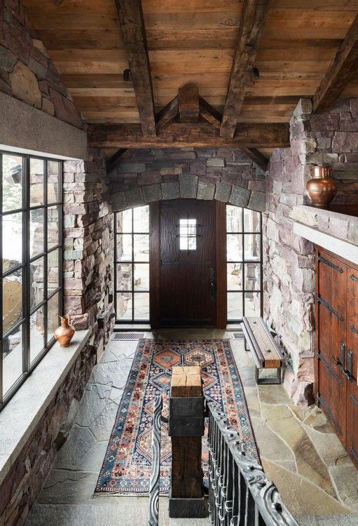 A hallway in a house with a wooden ceiling and a wooden door.