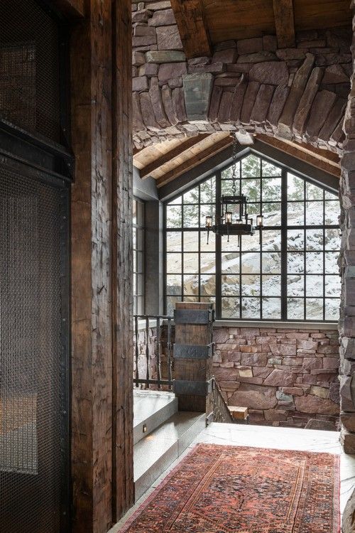 A bathroom with a large window and a rug on the floor.