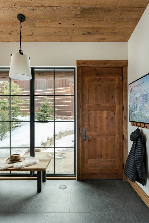 A hallway with a wooden door and a large window