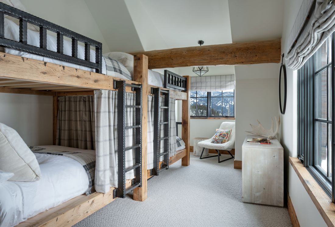 A bedroom with bunk beds and a chair in it.