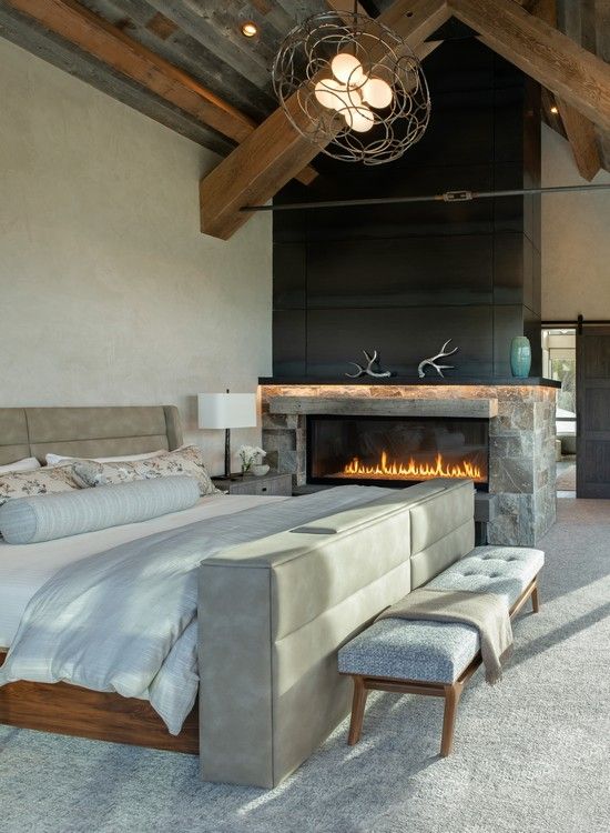 A bedroom with a fireplace and a large bed