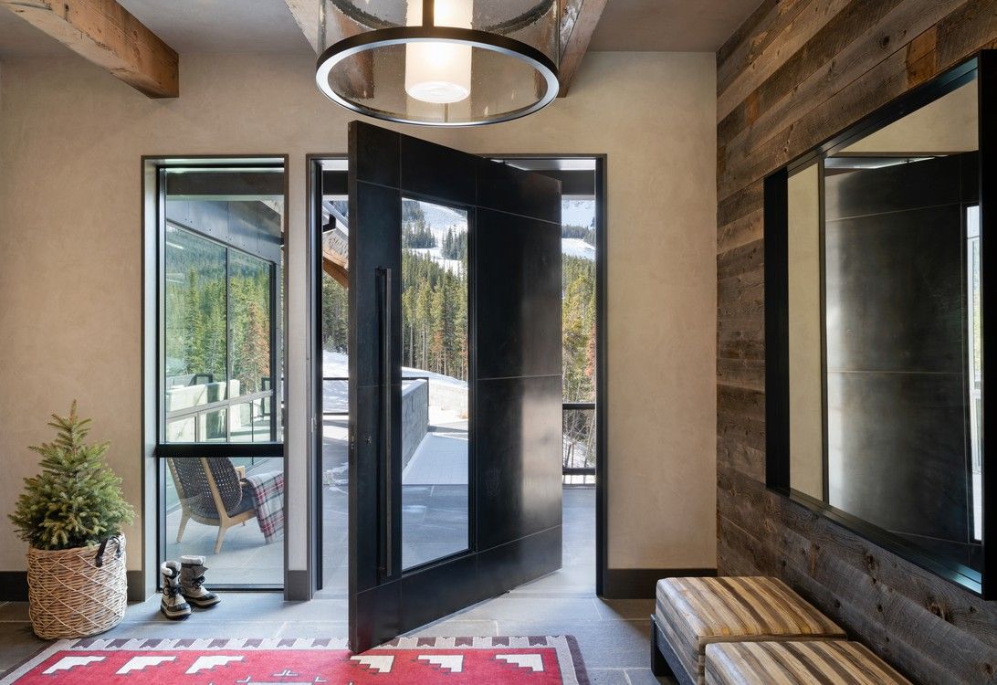 A hallway with a stainless steel door and a wooden wall.