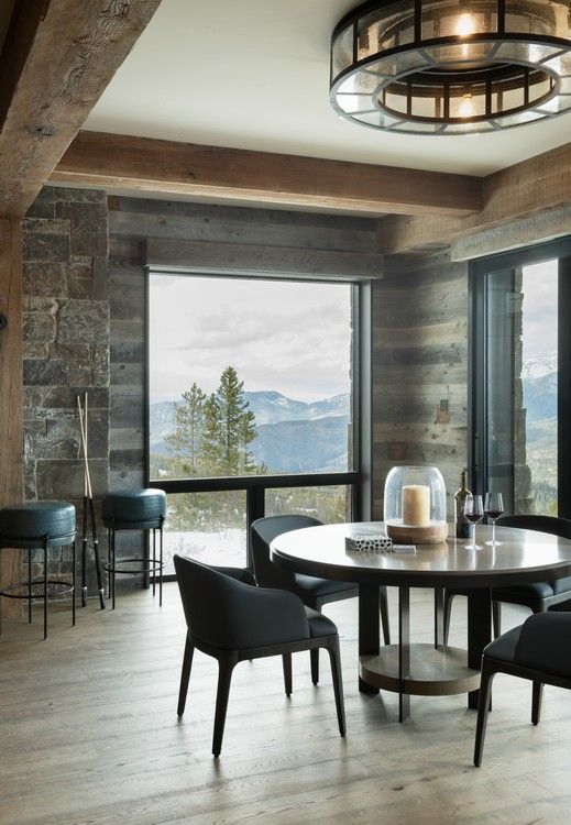 A dining room with a table and chairs and a large window.