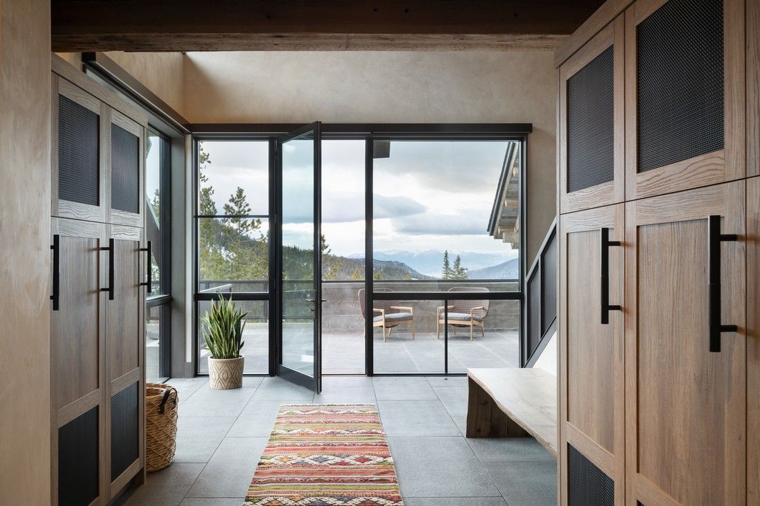 A hallway with lots of windows and a rug on the floor.