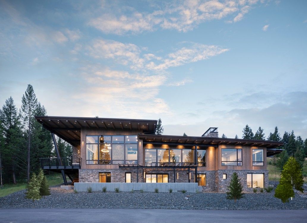 A large house with a lot of windows is sitting on top of a hill.